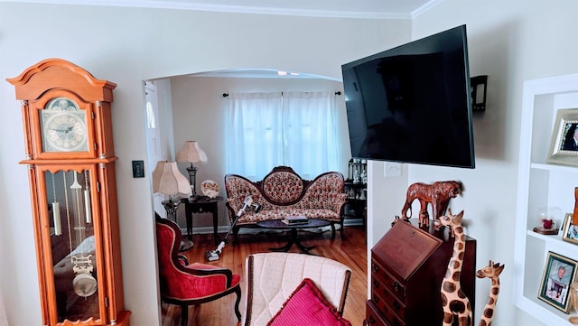 living area featuring crown molding and wood finished floors