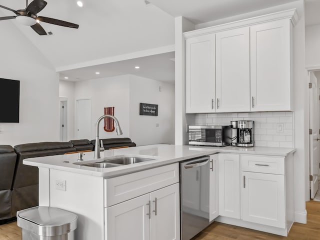 kitchen with open floor plan, light countertops, vaulted ceiling, stainless steel appliances, and a sink