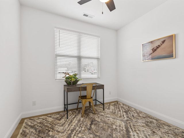 home office with a ceiling fan, visible vents, and baseboards