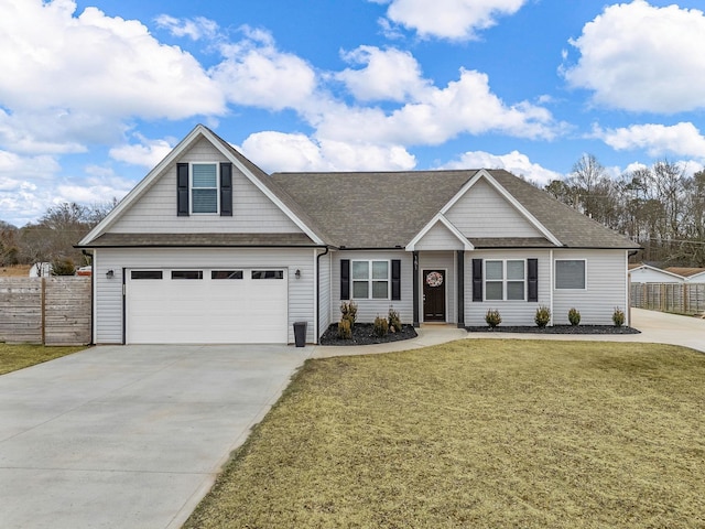 view of front of property featuring a garage, driveway, a front lawn, and fence