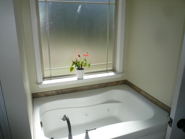 bathroom featuring a whirlpool tub and plenty of natural light