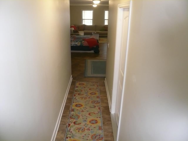 hallway featuring wood finished floors and baseboards