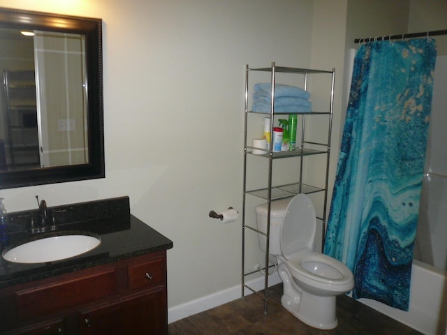 full bath featuring toilet, shower / bath combo, vanity, wood finished floors, and baseboards