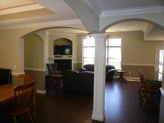 dining room with dark wood-style floors, ornamental molding, a fireplace, and baseboards