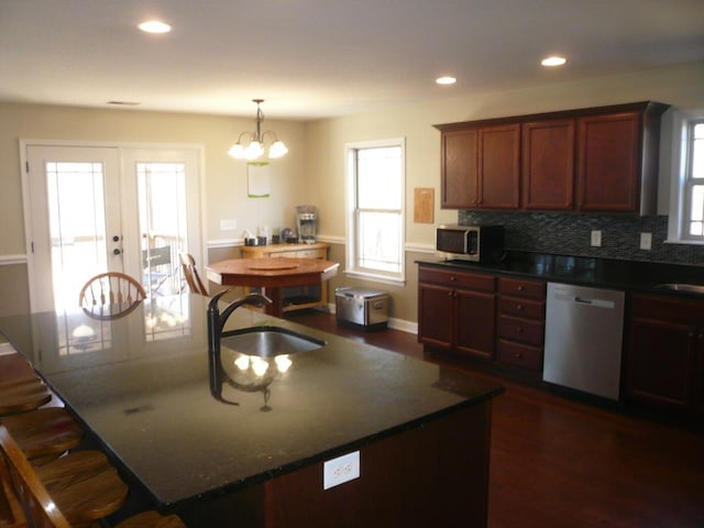 kitchen featuring stainless steel appliances, backsplash, a sink, and dark wood-style flooring