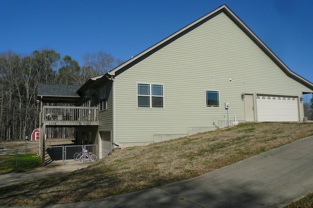 view of home's exterior with a gate, fence, and a deck