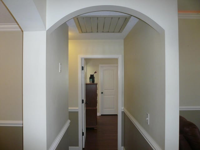 corridor with dark wood-type flooring, arched walkways, and visible vents