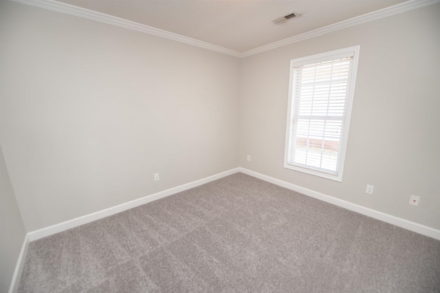 empty room featuring ornamental molding, carpet, visible vents, and baseboards