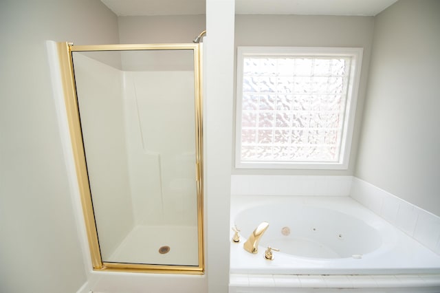 bathroom with a stall shower and a jetted tub