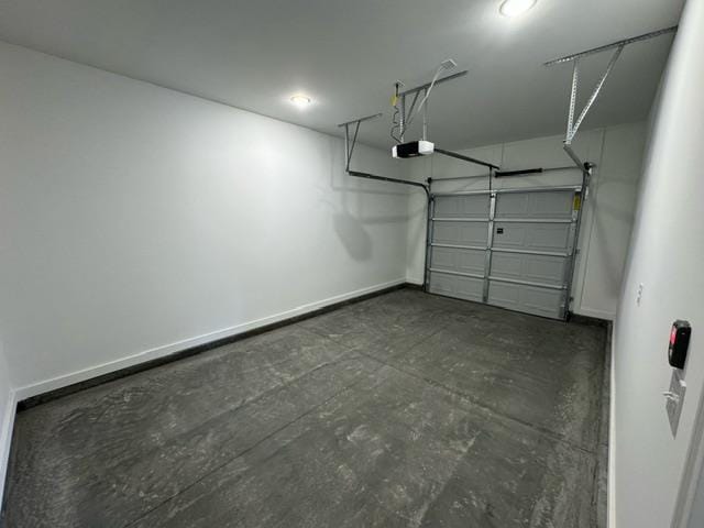 garage featuring a garage door opener and baseboards