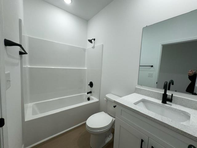 full bathroom featuring shower / washtub combination, toilet, and vanity