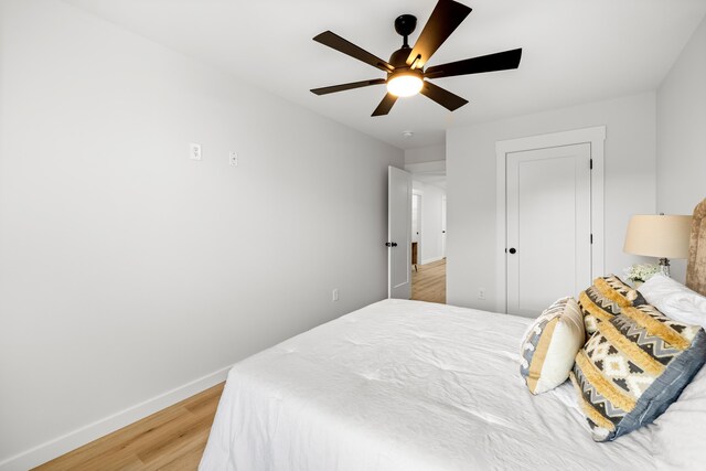 bedroom with a ceiling fan, light wood-type flooring, and baseboards