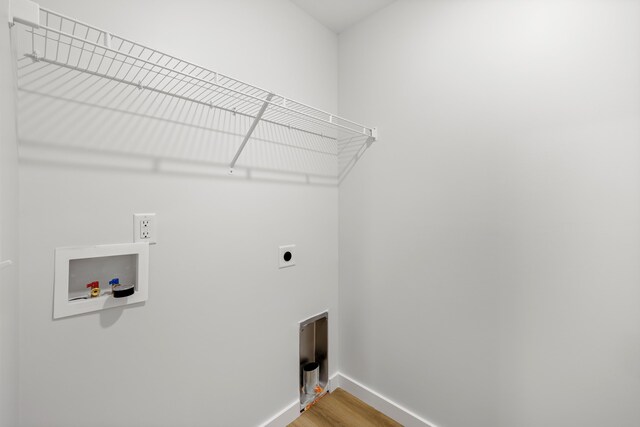 clothes washing area featuring baseboards, light wood-type flooring, laundry area, hookup for a washing machine, and hookup for an electric dryer