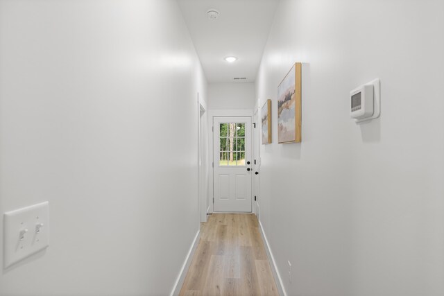 hallway with baseboards and light wood finished floors