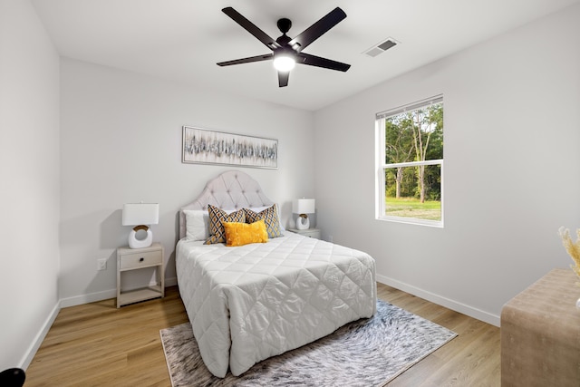 bedroom featuring visible vents, a ceiling fan, light wood-type flooring, and baseboards