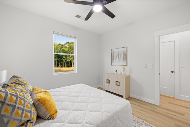 bedroom featuring visible vents, ceiling fan, baseboards, and light wood-style floors