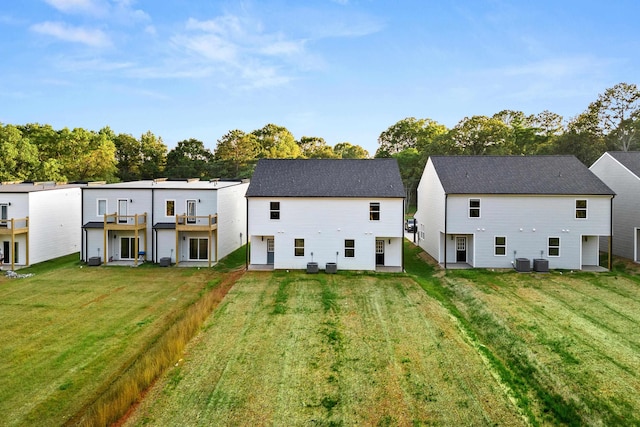 back of house featuring a lawn and central AC unit