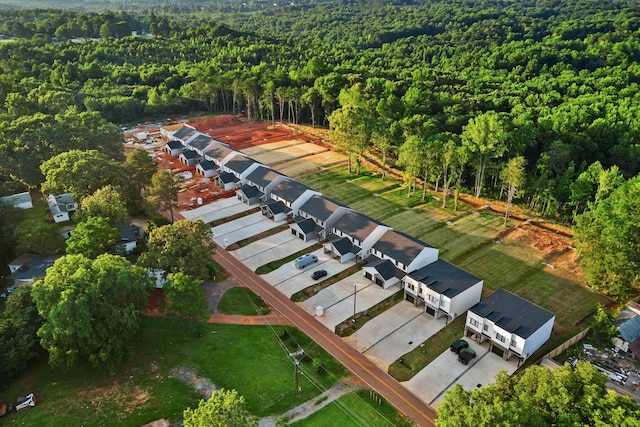 drone / aerial view featuring a residential view and a wooded view