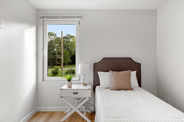 bedroom with wood finished floors and baseboards