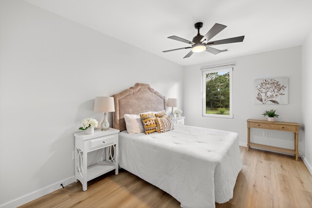 bedroom with baseboards, light wood-style floors, and a ceiling fan