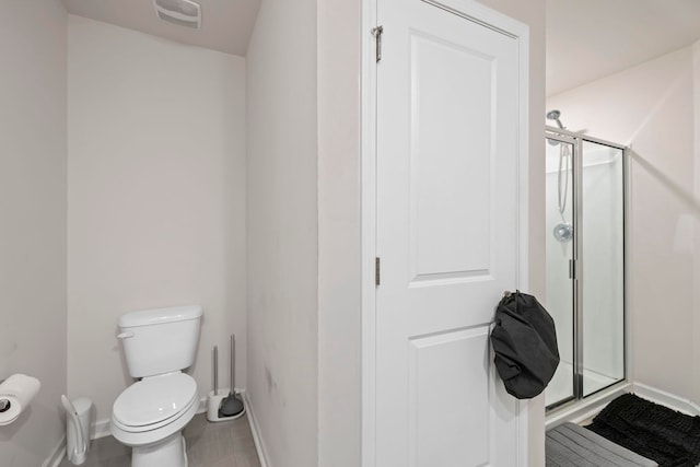 bathroom featuring visible vents, baseboards, toilet, and a stall shower