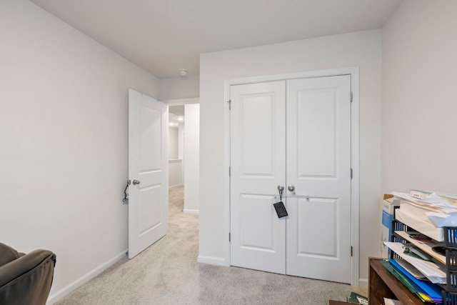 bedroom featuring baseboards, a closet, and light carpet