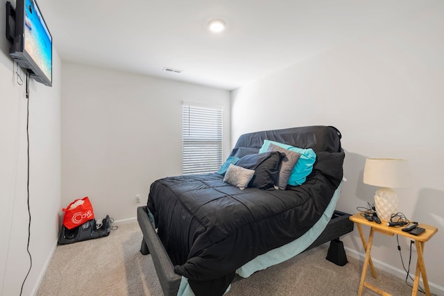 carpeted bedroom featuring visible vents and baseboards