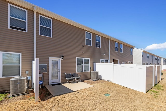 rear view of house featuring a patio area, central air condition unit, and fence