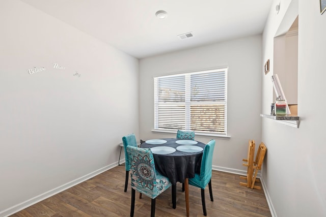 dining room with visible vents, baseboards, and wood finished floors