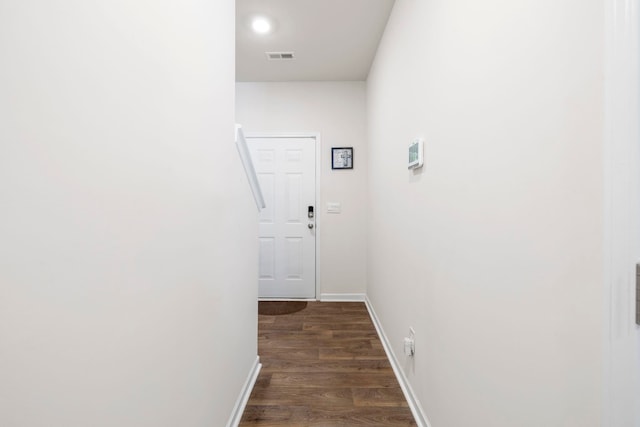 hall featuring dark wood finished floors, visible vents, and baseboards