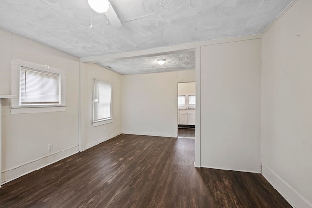 spare room featuring baseboards and wood finished floors