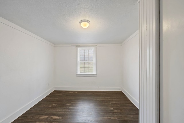 spare room with dark wood finished floors, baseboards, and a textured ceiling