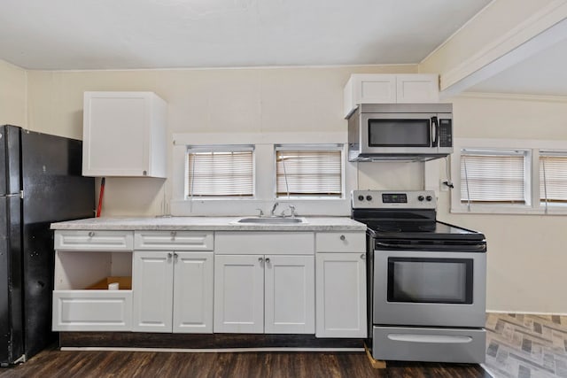 kitchen featuring a sink, stainless steel appliances, white cabinets, light countertops, and dark wood-style flooring