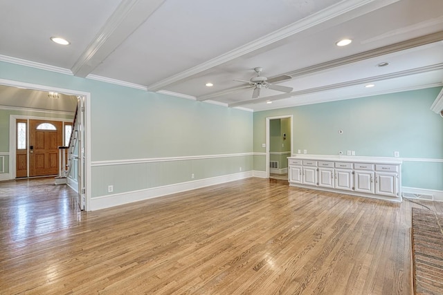 empty room with ceiling fan, beamed ceiling, light wood-style floors, and ornamental molding