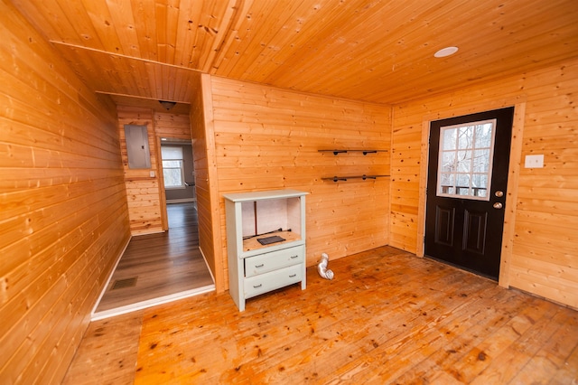 foyer with plenty of natural light, wood walls, and hardwood / wood-style flooring