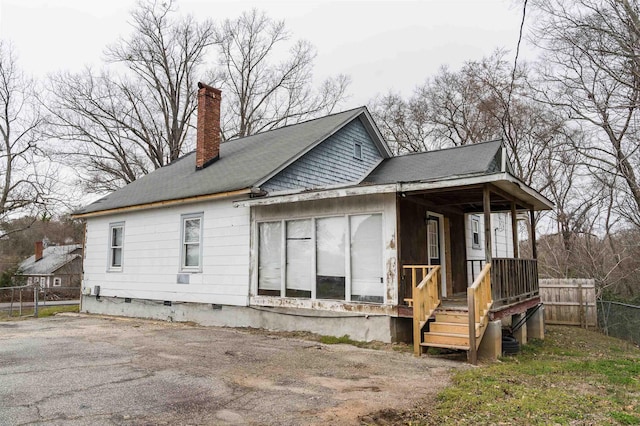 rear view of house featuring crawl space, a chimney, and fence