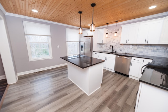 kitchen with dark countertops, crown molding, wood ceiling, stainless steel appliances, and a sink