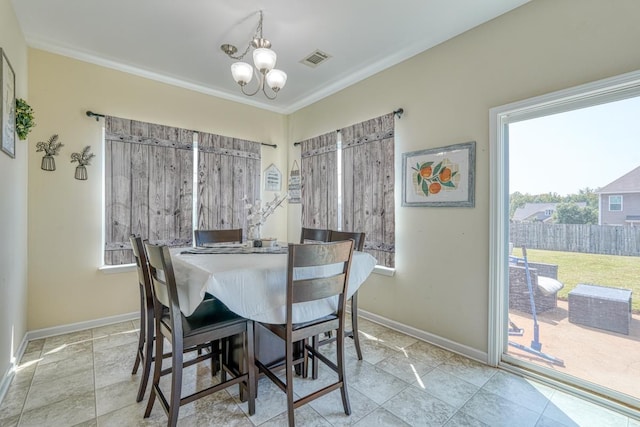 dining area featuring crown molding, baseboards, visible vents, and a chandelier