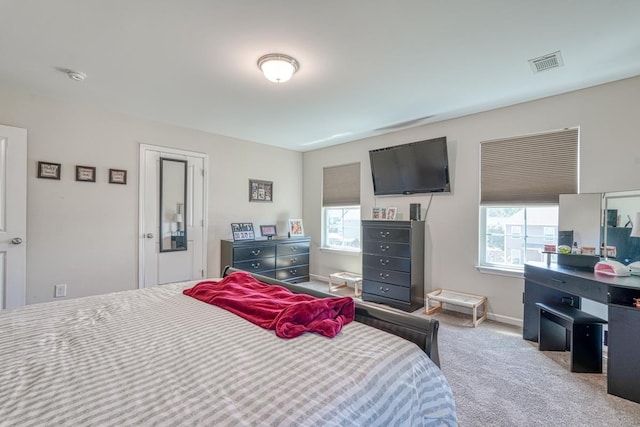 bedroom with visible vents, multiple windows, carpet flooring, and baseboards