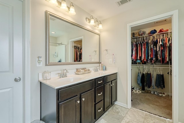 bathroom with double vanity, visible vents, and a sink