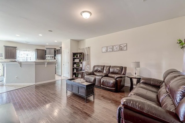 living room with recessed lighting, baseboards, and wood finished floors