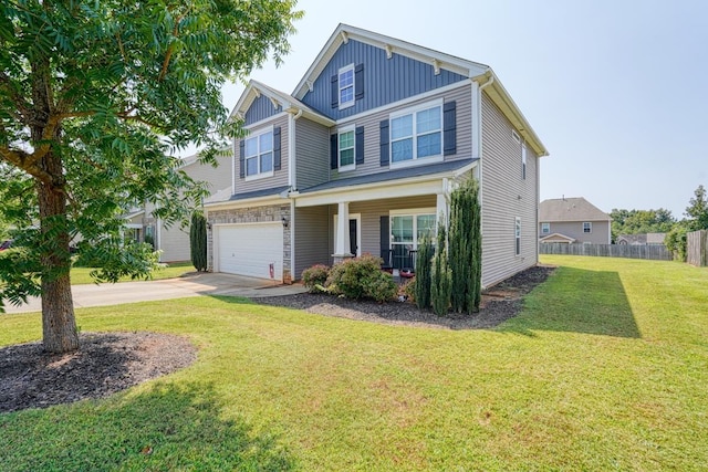 craftsman house with fence, concrete driveway, a front lawn, a garage, and board and batten siding