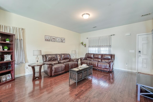 living room featuring wood finished floors, visible vents, and baseboards