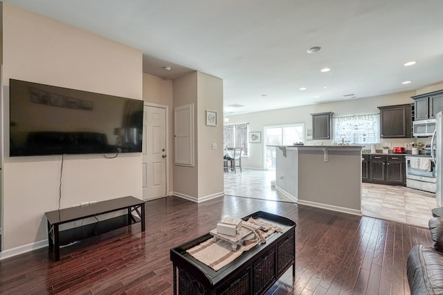 living area featuring hardwood / wood-style floors, recessed lighting, and baseboards