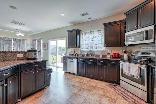 kitchen featuring dark stone countertops, visible vents, appliances with stainless steel finishes, and a sink