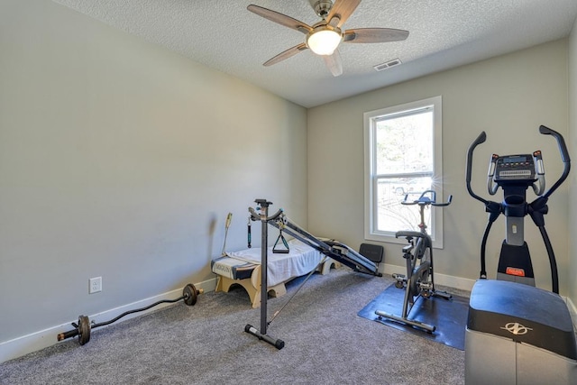 exercise area with visible vents, a textured ceiling, carpet floors, baseboards, and ceiling fan