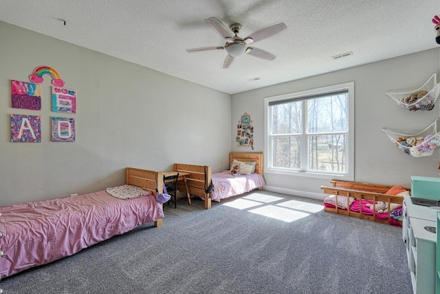 bedroom featuring visible vents, carpet floors, a textured ceiling, and ceiling fan