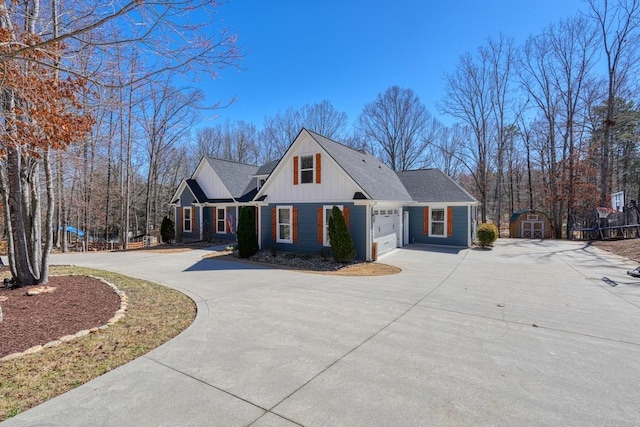 view of front of house featuring a storage unit, board and batten siding, an outdoor structure, concrete driveway, and an attached garage