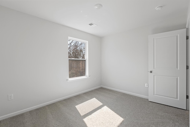 empty room with visible vents, carpet floors, and baseboards