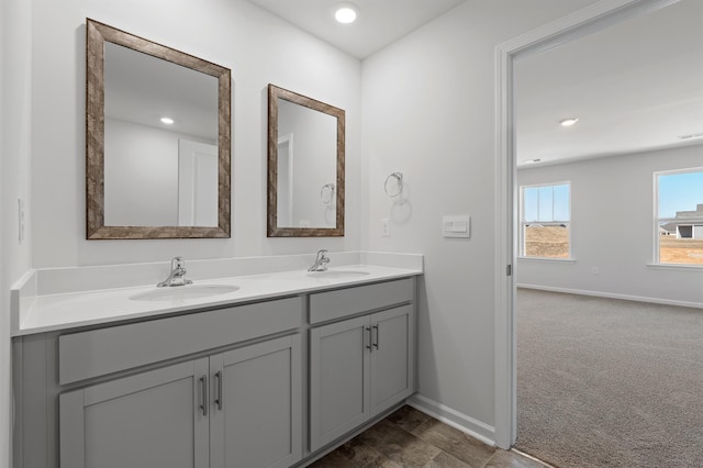 bathroom featuring a sink, baseboards, and double vanity